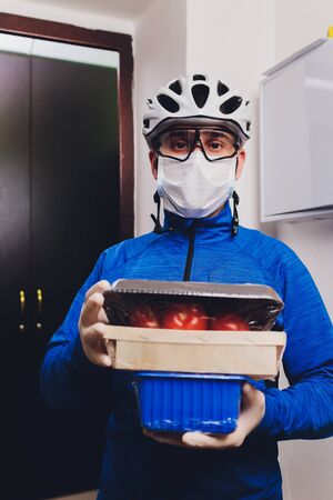 Delivery man holding food delivery from the nearest store in medical rubber gloves and mask. copy space. Fast and free Delivery transport . Online shopping and Express delivery . Quarantine.の写真素材
