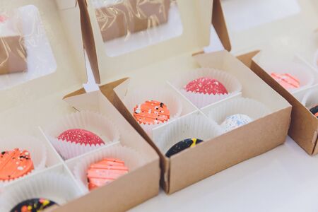 Cupcake packaging, delivery box, vanilla cupcakes with pink and white cream, selective focus, close...