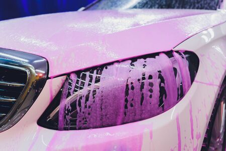 Close up cleaning car using high pressure water,High pressure jet washer in process of car washing pink color foamの写真素材