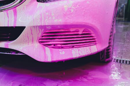 Close up cleaning car using high pressure water,High pressure jet washer in process of car washing pink color foamの写真素材