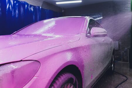 Close up cleaning car using high pressure water,High pressure jet washer in process of car washing pink color foamの写真素材