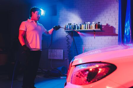 Close up cleaning car using high pressure water,High pressure jet washer in process of car washing. pink color foamの写真素材