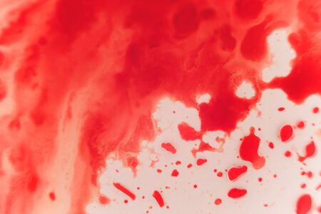Fresh red blood splat on white porcelain with specks from the impact. Copy space area for horror themed concepts and ideas. macroの写真素材