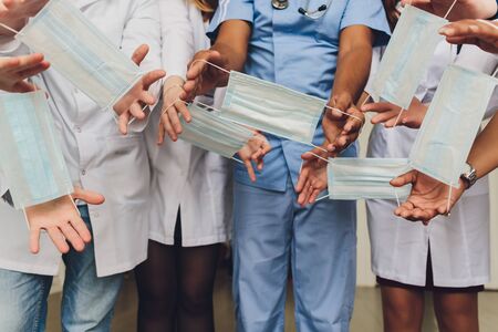 Doctor or Nurse Wearing Surgical Gloves Holding A Few Medical Face Masks.の写真素材