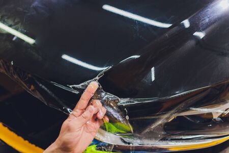 Transparent film, car paint protection, wrapping specialis. Car detailing. Selective focus.の写真素材
