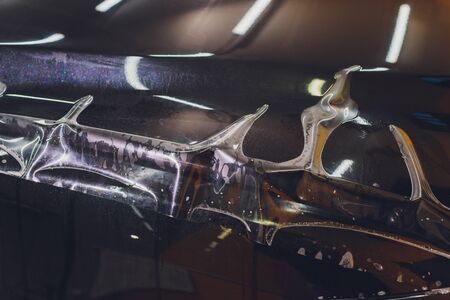 Transparent film, car paint protection, wrapping specialis. Car detailing. Selective focus.の写真素材