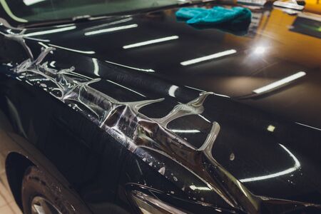 Transparent film, car paint protection, wrapping specialis. Car detailing. Selective focus.の写真素材
