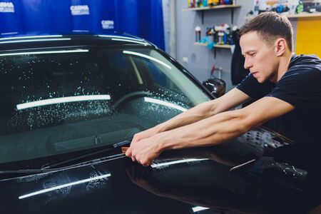 Transparent film, car paint protection, wrapping specialis. Car detailing. Selective focus.の写真素材