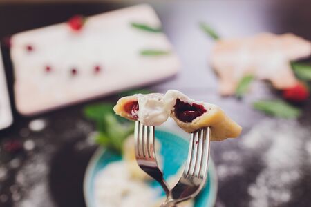 Dumplings, filled with strawberries. Varenyky, vareniki, pierogi, pyrohy - dumplings with filling. View from above, top studio shot.の写真素材