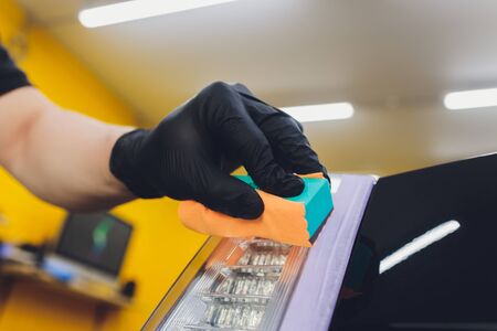 Car detailing - Man applies nano protective coating to the car. Selective focus.の写真素材