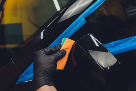 Car detailing - Man applies nano protective coating to the car. Selective focus.の写真素材