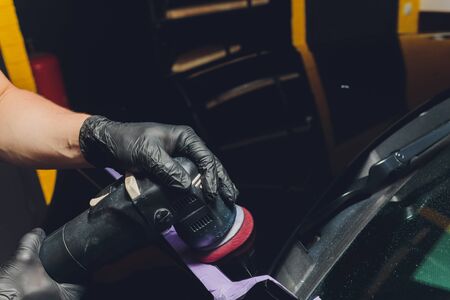 Car detailing - Hands with orbital polisher in auto repair shop. Selective focus.の写真素材