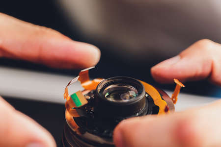 Big professional digital camera lens dissassembly process.Demounted broken dslr optics on table in workshopの写真素材