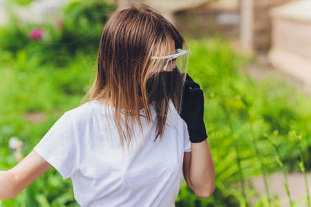 Portrait happy woman wile wearing a face shield for protection from cold and flu and viruses. Young...