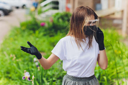 Portrait happy woman wile wearing a face shield for protection from cold and flu and viruses. Young woman with face mask in the street. Woman wearing face mask because of air pollution in the city.の写真素材