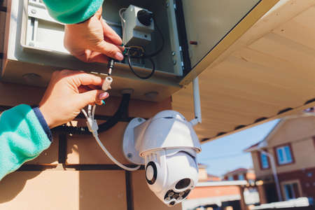 technician female setup cctv camera on wall.の写真素材