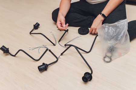 Chandelier with wires and tools on the floor, preparation to installation.