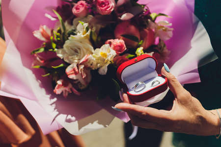 Close up of man holding wedding ring and gift box.の写真素材