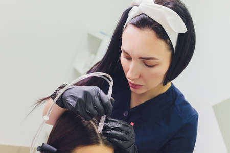 Gas-liquid hair peeling, dandruff cleansing. young woman.の写真素材