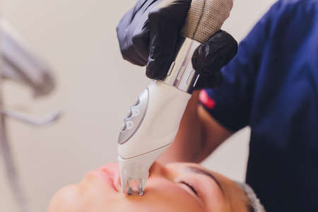 Lymphatic drainage massage LPG apparatus process. Therapist beautician makes a rejuvenating facial massage for the model in a beauty salon. Close up, selective focus.の写真素材