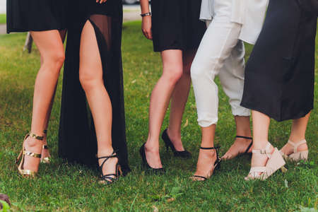 Close up of woman feet in summer sandals shoes walking on spring lawn covered with fresh green grass.の写真素材