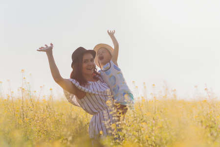 beautiful young mother and her daughter having fun at the wheat field.