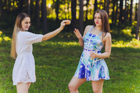 Smiling woman having a relaxing lunch break outdoors, she is sitting on the grass and eating.の写真素材