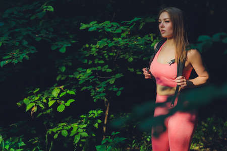 Smile girl exercising outdoors in green park, activity with stretch arms. Young fitness woman doing...