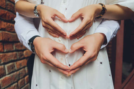 Closeup of couple making heart shape with hands.の写真素材