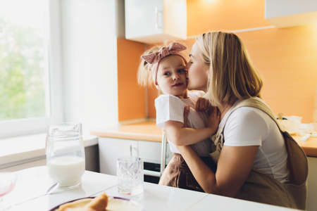 Portrait of an adorable mother and daughter preparing a daughter together in the kitchen.の写真素材