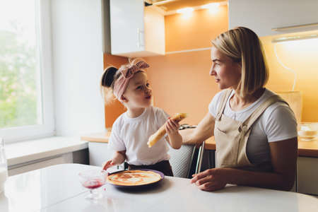 Portrait of an adorable mother and daughter preparing a daughter together in the kitchen.
