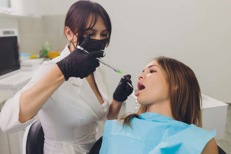 Dentist examining a patients teeth in the dentist.の写真素材