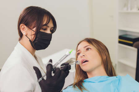 Dentist examining a patients teeth in the dentist.の写真素材