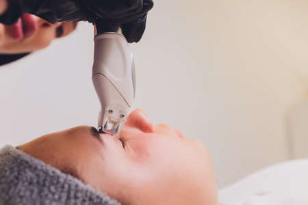 Lymphatic drainage massage LPG apparatus process. Therapist beautician makes a rejuvenating facial massage for the model in a beauty salon. Close up, selective focus.の写真素材