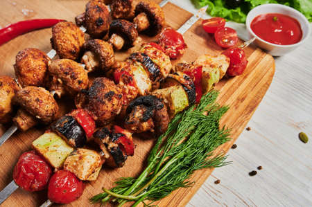 lamb shish kebab with vegetables on a wooden Board.の写真素材