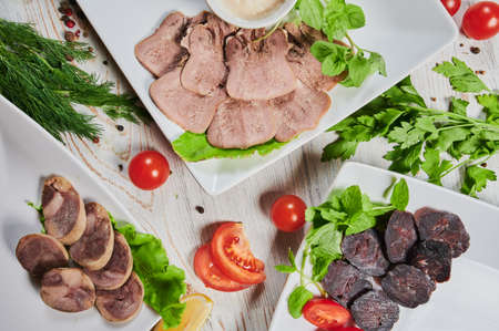 Dinner table with meat grill, roast new potatoes, vegetables, salads, sauces, snacks and lemonade, top view.の写真素材