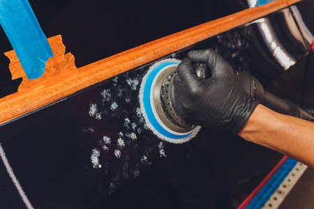 Hands with Auto polisher. Car repair service.