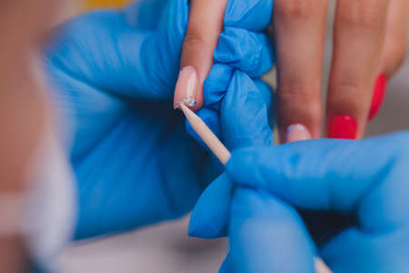 woman doing manicure in a beauty salon. Close-up of hands.の写真素材