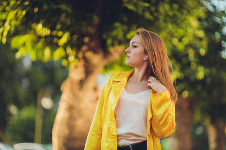 Displaying fashion tendencies. Dark-haired attractive woman posturing in bright yellow fluffy cloak.の写真素材