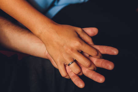 Close up black woman and man in love sitting on couch two people holding hands. Symbol sign sincere...