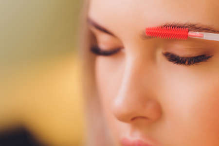 Young woman having professional eyebrow correction procedure in beauty salon.の写真素材