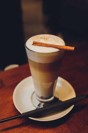 Latte coffee with cinnamon stick on wooden table.の写真素材