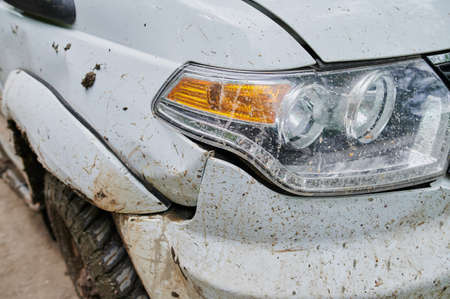 Dirty white car, but clean headlight broken bumper.の写真素材
