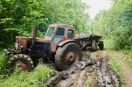 Old tractor in the spring forest. Equipment for logging.