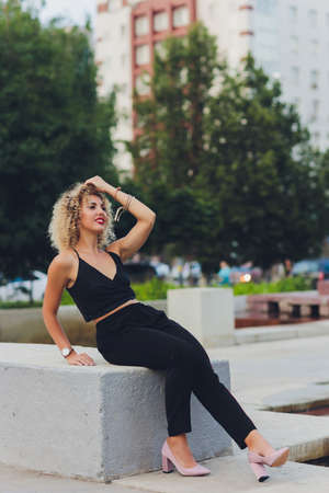 Beautiful young Caucasian girl with curly hair outdoors.