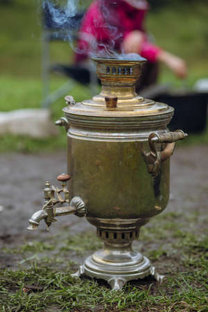 Russian samovar boils water for a traditional tea party in nature.の写真素材