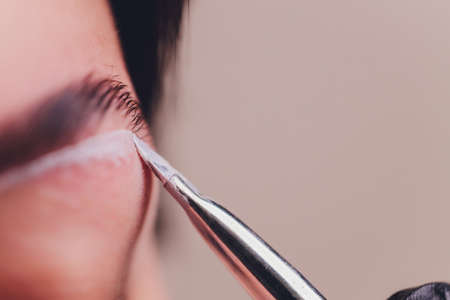 Young woman having professional eyebrow correction procedure in beauty salon.の写真素材
