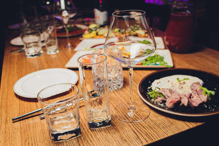 Served for holiday banquet restaurant table with dishes, snack, cutlery, wine and water glasses. European food.の写真素材