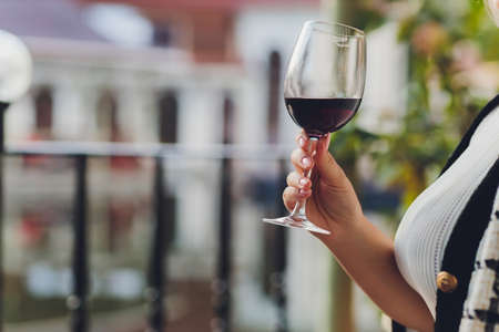 Close up shot of group of people clinking glasses with wine or champagne in front of bokeh background. older people hands.の写真素材