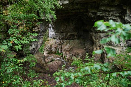 view of a small mountain river waterfall among large cobblestones from a cliff.の写真素材